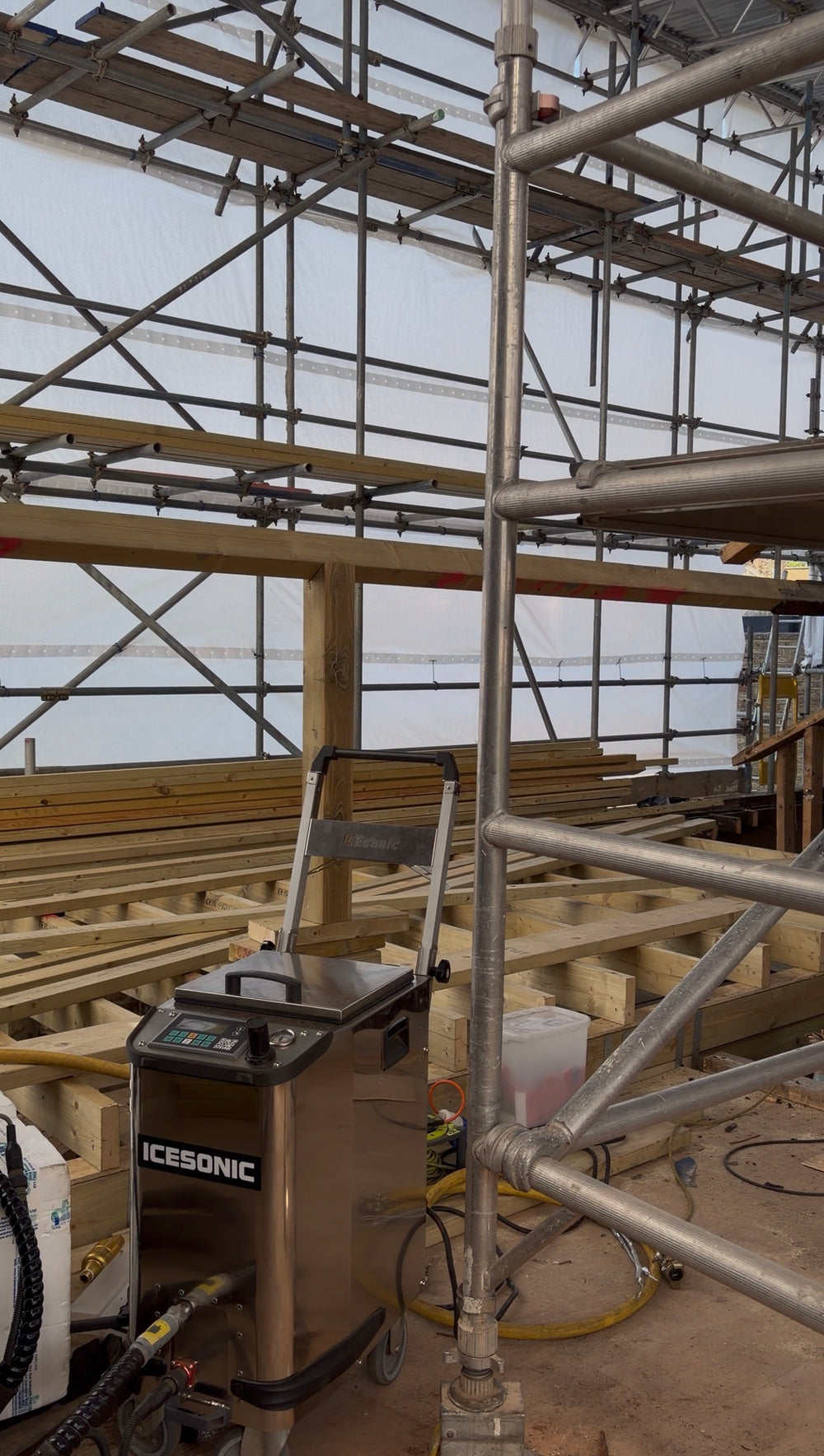 Dry ice blasting machine in fire damaged property with roof timbers and scaffolding