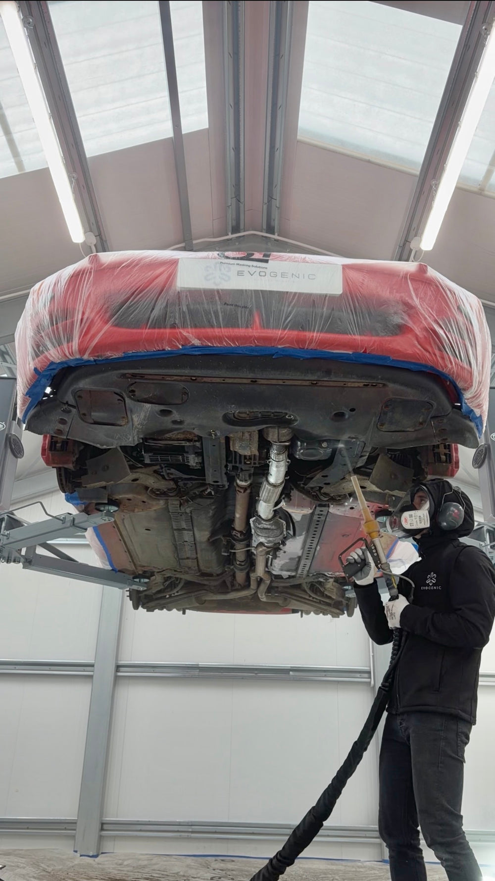 Dry ice blasting red car on lift at workshop
