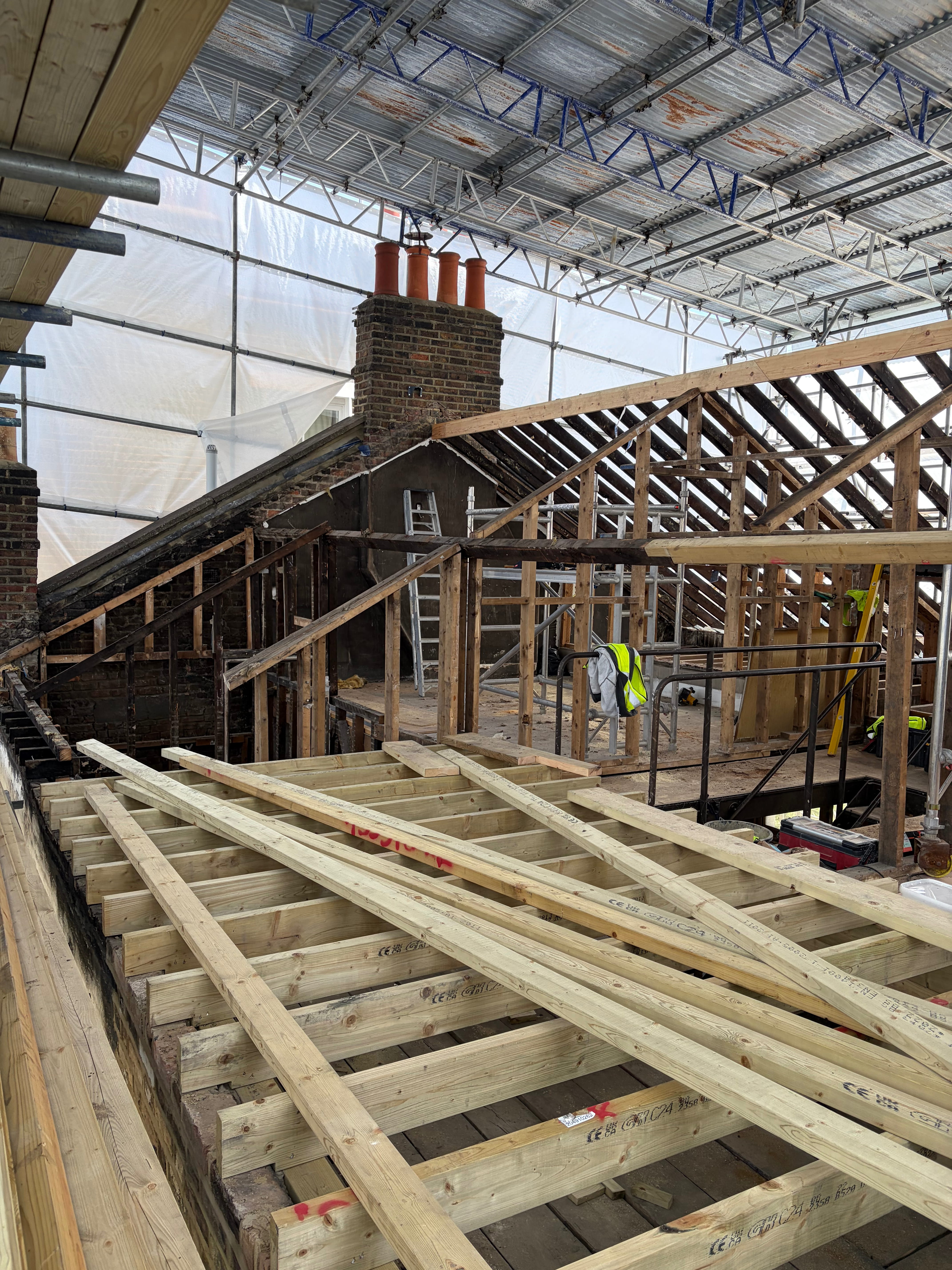 Construction site with fire damaged wooden roof beams before dry ice blasting