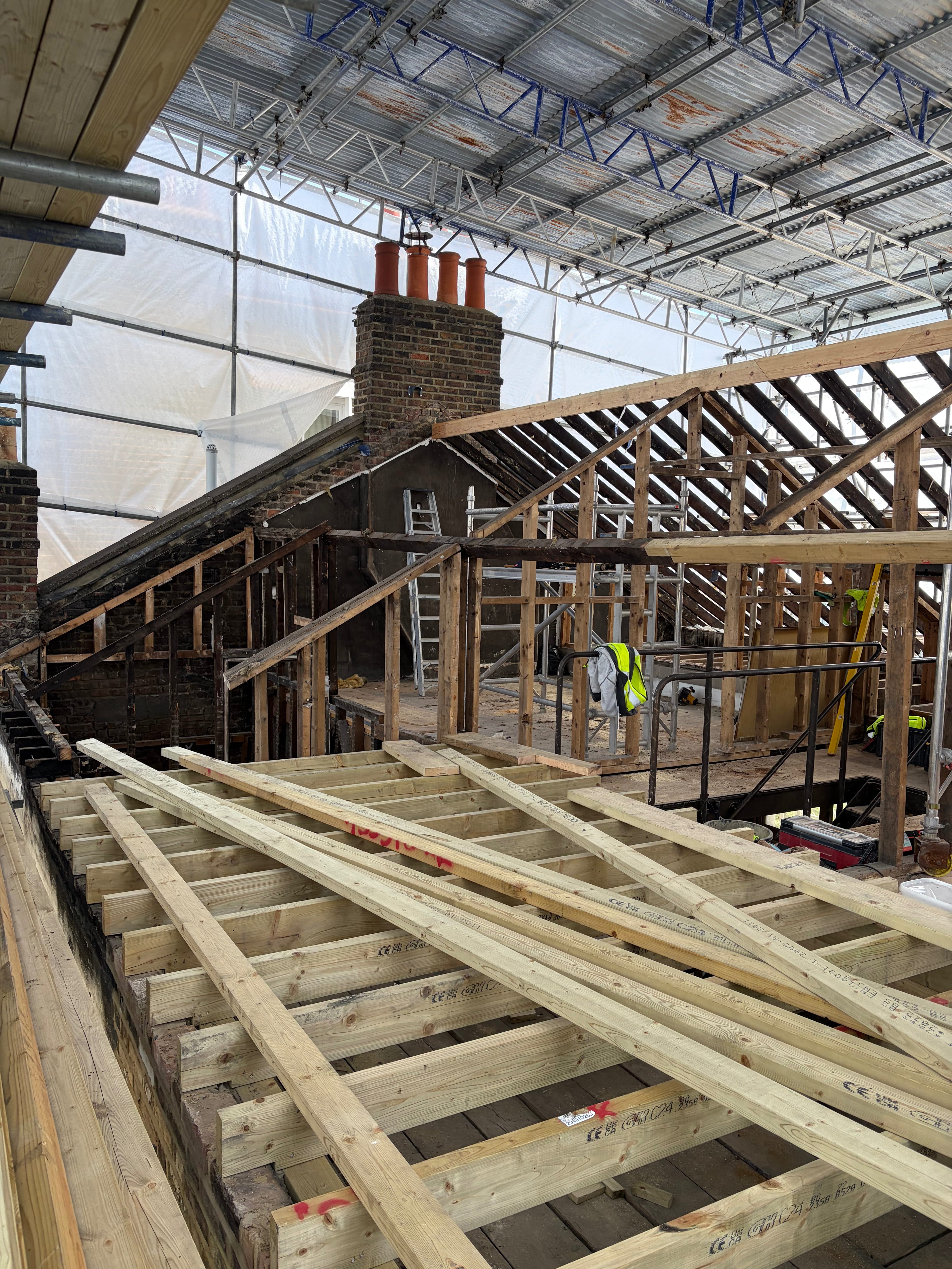 Construction site with fire damaged wooden roof beams before dry ice blasting