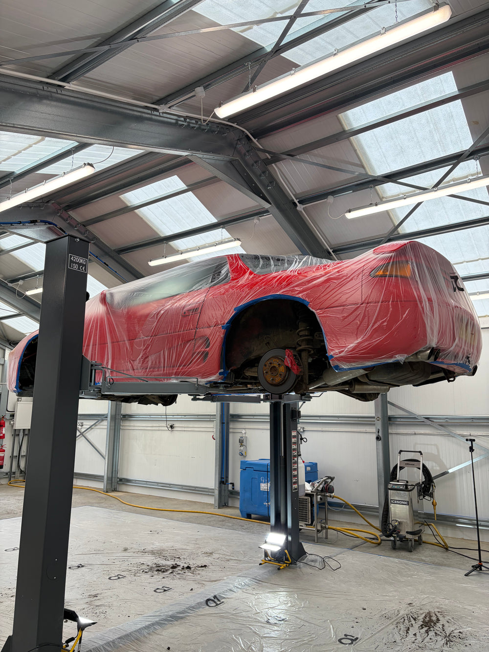 Mitsubishi GTO on lift with dust sheet during dry ice blasting