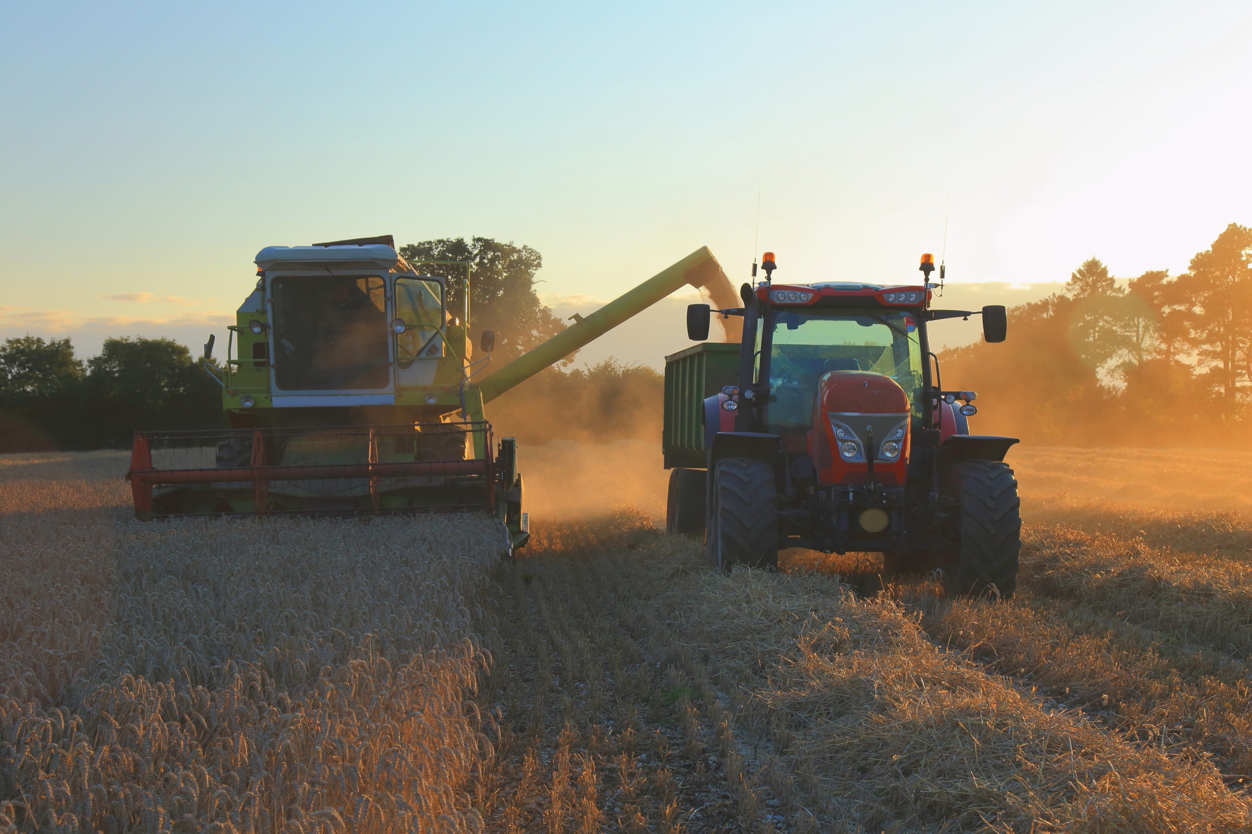 Tractor and combine harvester in a field.